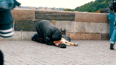 12.-September-2017---Prag,-Tschechische-Republik:-armer-Mann-mit-einem-Hund-bittet-um-Geld-oder-Almosen-mit-einer-ausgestreckten-Hand-an-Passanten-auf-der-Karlsbrücke-in-Prag