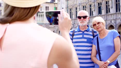 Tochter-nehmen-Foto-ihrer-älteren-Eltern-auf-Urlaubsreise-in-zentralen-Platz-von-Brüssel,-Belgien