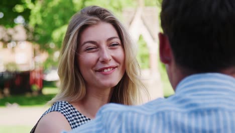 Businesswoman-Talking-To-Male-Colleague-On-Break-In-Park