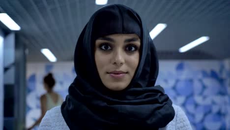 Young-charming-muslim-woman-in-hijab-is-standing-in-underpass,-watching-at-camera,-religion-concept