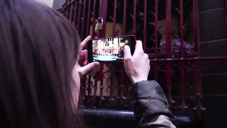 Lady-tourist-takes-pictures-of-Jeanneke-Pis-fountain-in-Brussels.-Belgium