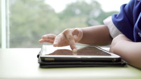 Asiatische-kleine-Schülerin-spielen-schreiben-auf-Smartphones-im-café