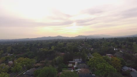 Vista-aérea-del-barrio-y-montañas-durante-la-puesta-de-sol-en-California