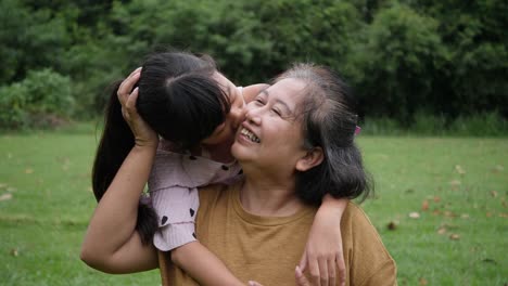 Slow-motion-of-Happy-grandmother-with-granddaughter-playing-in-the-park