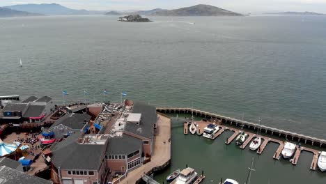 Aerial-Shot-Flying-Backwards-Over-Pier-39-and-the-Surrounding-Boats-in-San-Francisco,-California