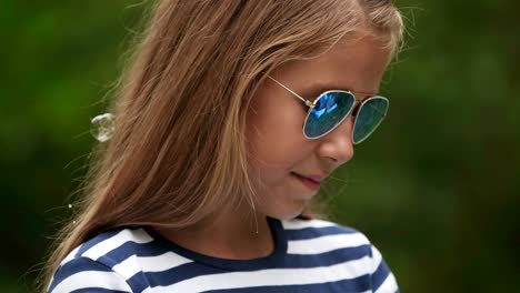 Little-girl-playing-with-soap-bubbles-outdoor.-Slow-motion.