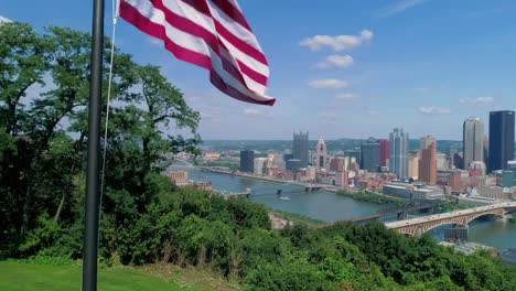 Steigende-Luftaufnahme-der-amerikanischen-Flagge-und-Skyline-von-Pittsburgh