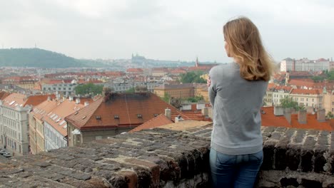 schlanke-blonde-Frau-ist-Panorama-Blick-auf-die-Stadt-Prag-in-windigen-Wetter-bewundern.