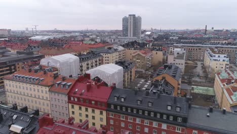 Drone-shot-over-city-buildings-in-Stockholm,-Sweden.-Aerial-view-of-Södermalm-district-rooftops-cityscape-skyline