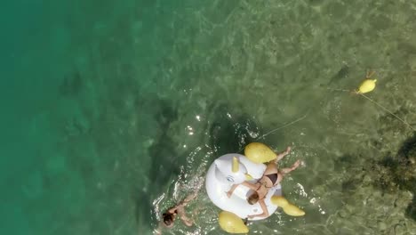 Aerial-view-of-woman-pulling-inflatable-with-friend-in-Panagopoula,-Greece.