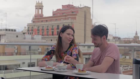 Una-pareja-disfrutando-de-café-y-postres-en-un-café-en-la-azotea-de-Valencia