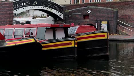 Close-Up-of-Three-Narrow-Boat-Barges-Lined-in-a-Row-By-Bridge