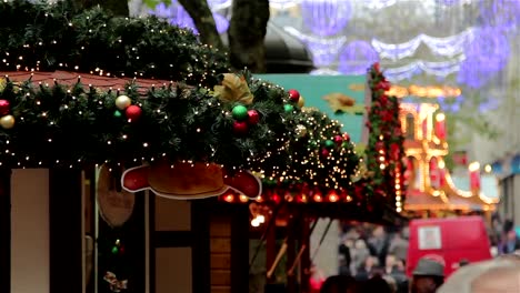 Pull-Focus-through-Twinkling-Xmas-Lights,-Large-Crowd-German-Christmas-Market