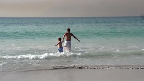 Dos-chicos-correr-en-el-mar,-la-Ciudad-del-Cabo,-Sudáfrica