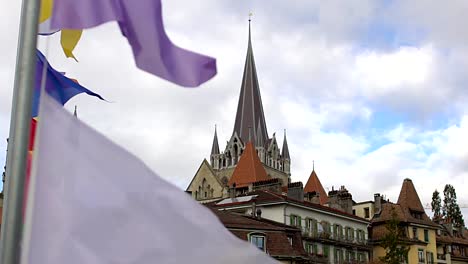 Bunte-Banner,-die-im-Wind-schwingen,-schöner-Blick-auf-die-Kathedrale-von-Lausanne-Notre-Dame