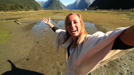 Young-woman-takes-selfie-portrait-on-mountain-background