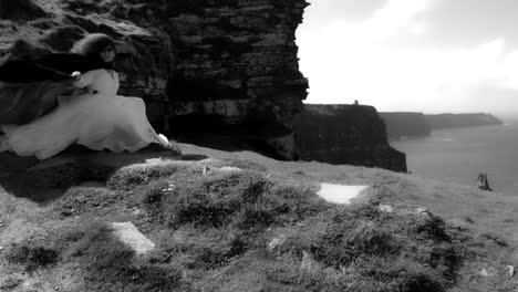 4k-Shot-of-a-Redhead-princess-on-Cliffs-of-Moher-View-in-Ireland,-black-&-white