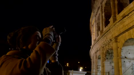 Woman-with-retro-camera-shooting-Coliseum-at-night