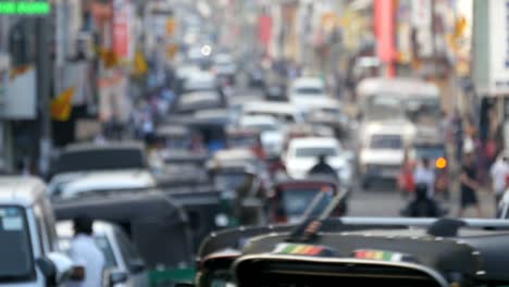 Blurred-unrecognizable-people-are-walking-around-city-center.-Cars-drive-on-roads-in-the-town.-Out-of-focus-is-backdrop-of-bustling-big-city-with-busy-traffic