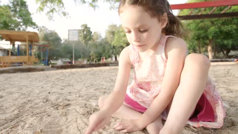 Kleines-Mädchen-in-einer-Sandbox-auf-einem-Spielplatz-spielen