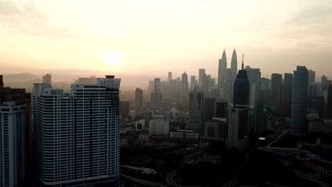 Cielo-ardiente-contra-rascacielos-de-Kuala-Lumpur-con-niebla-y-niebla-por-la-mañana.