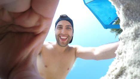 Chico-brasileño-joven-tomando-un-selfie-en-la-playa