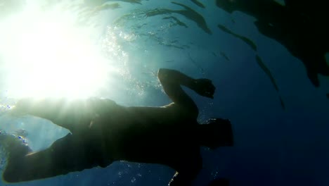 4-K-Silhouette-der-Taucher-mit-der-Sonne-Strahlen-bellow-das-Wasser