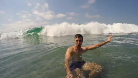 Chico-brasileño-joven-divirtiéndose-y-teniendo-un-selfie-en-la-playa