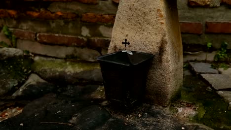 Stone-cross-standing-near-church,-symbol-of-unquestioning-faith-and-worship