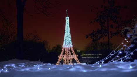 Effel-Türmchen-in-Lichter-in-der-Nacht-mit-dunklen-orangefarbenen-Himmel-im-Hintergrund