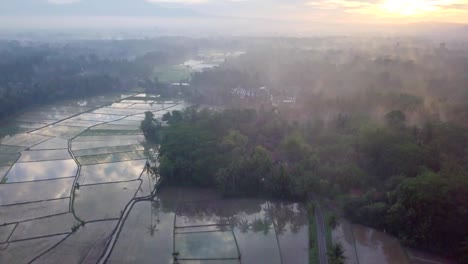 Aerial-view-drone-shot-of-Borobudur-town-in-Java-at-sunrise,-Indonesia-Travel-religion-drone-concept-4K-resolution-Rice-fields-and-volcano