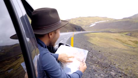 4K-junger-Mann-im-Auto-Blick-auf-Karte,-Road-Trip-Konzept-Urlaub