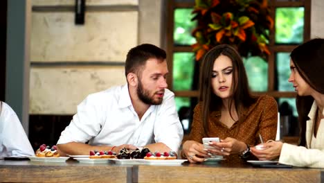 Cheerful-multiracial-friends-taking-selfie-in-pizzeria