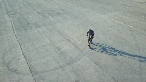 flying-view-of-young-rider-doing-tricks-on-bmx-bike-in-the-urban-street-on-asphalt-surface