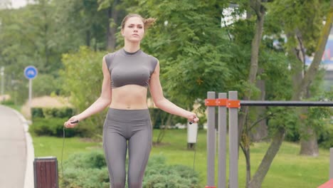 Fitness-woman-training-outdoor-with-skipping-rope-in-summer-park.