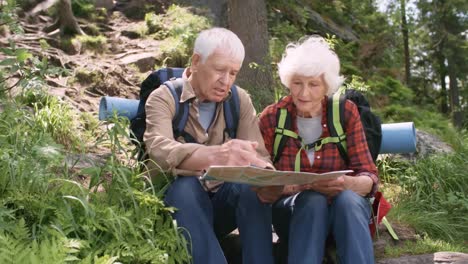 Elderly-Hikers-Checking-Route-on-Map-in-Forest