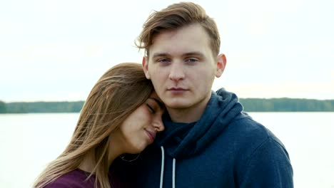 Portrait-of-two-teenagers,-a-guy-and-a-girl,-against-the-background-of-a-river-and-forest.