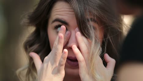 Candid-woman-removing-glasses-and-rubbing-eyes-while-listening-to-friend-speak