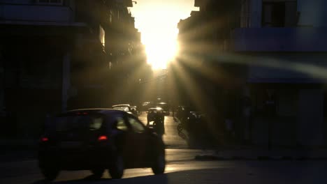 golden-hour-sun-rays,-old-classic-American-1950's-Vintage-car-drive-on-street-in-old-Havana-neighborhood,-Cuba