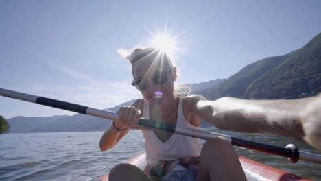 Junge-Frau-unter-Selfie-Porträt-in-rote-Kanu-am-Berg-See-eine-weibliche-genießen-Sommerferien-Spaß-bei-Outdoor-Aktivitäten---4K