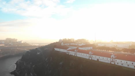 Aerial-view-of-buildings-on-a-cliff-during-sunset/sunrise