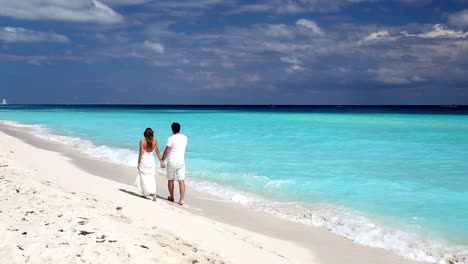 Young-beautiful-newlyweds-on-white-sandy-beach