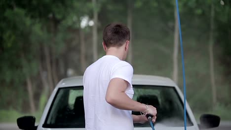man-in-a-white-t-shirt-white-car-washes.-Slow-motion