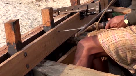 indian-worker-with-primitive-drill-drilling-new-boat-wood