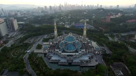 Luftbild-von-Sonnenaufgang-im-Federal-Moschee-Kuala-Lumpur-mit-Blick-auf-die-Skyline-der-Stadt-im-Hintergrund.