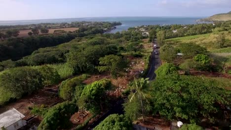 Flying-over-Mauritius-with-coastal-river,-town-and-sugarcane-fields