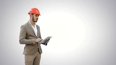 Engineer-in-safety-helmet-conducting-inspection-with-tablet-on-white-background