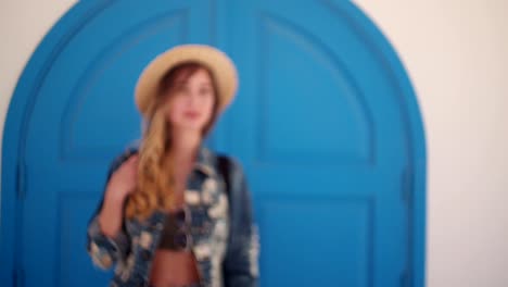 Woman-on-Mediterranean-vacations-standing-in-front-of-blue-door