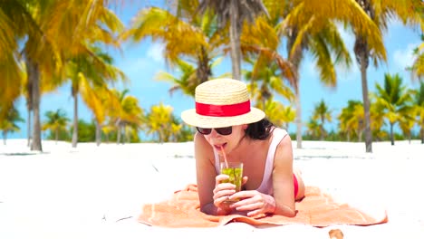 Junge-schöne-Frau-Entspannen-Sie-mit-einem-cocktail-auf-einem-weißen-tropischen-Strand