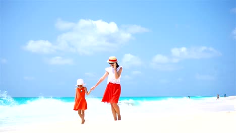 Little-cute-girl-and-young-mother-at-tropical-beach